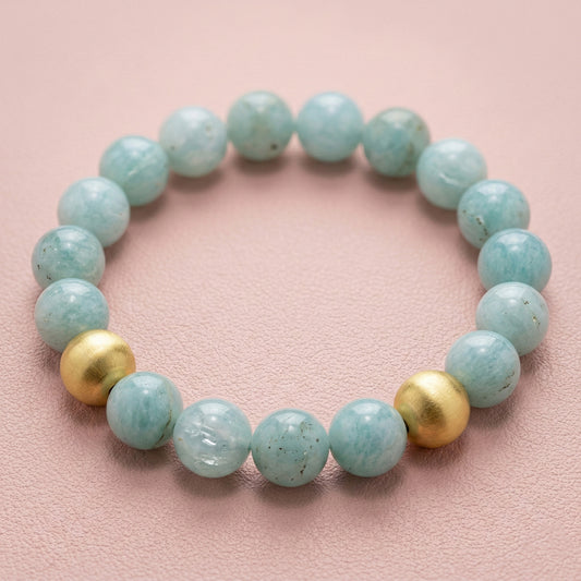 Beaded Aquamarine bracelet with 18K gold accents on a light pink background