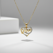 Gold and silver heart-shaped pendant with 'love' engraving on a gray background