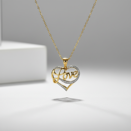 Gold and silver heart-shaped pendant with 'love' engraving on a gray background