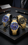 Three watches with blue and gold accents on a dark surface