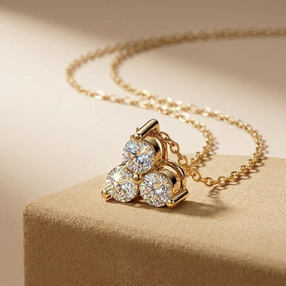 Gold necklace with diamond pendant on a beige surface