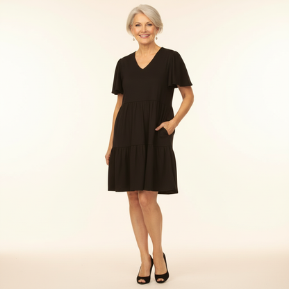 Woman wearing a black dress on a beige background
